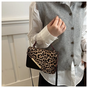 Detail of leopard print faux fur and black leather stitching with gold metal accent