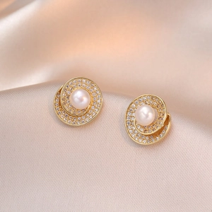Elegant geometric gold pearl earrings with sparkling zircon accents on champagne silk background