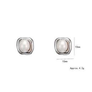 Irregular square silver stud earrings with pearl center inlay on white background