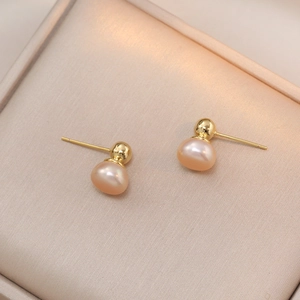 Elegant gold S925 silver stud earrings with pink freshwater pearls on silk background