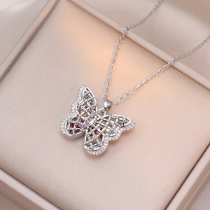 Exquisite silver butterfly necklace with colorful gems and zircon pavé on a jewelry box