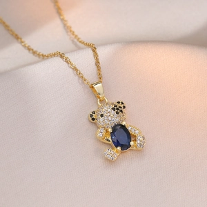 Sparkling gold bear necklace with micro-pave crystals and blue stone on silk
