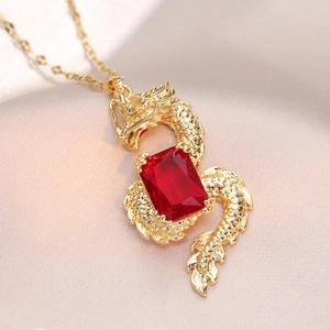 Golden dragon pendant necklace with a rectangular red zircon on pink silk background