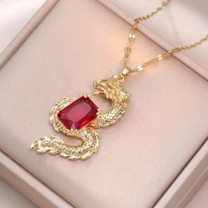 Golden dragon necklace featuring a vivid red zircon pendant on pink satin jewelry box