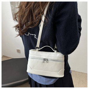 Détail du petit sac boîte en cuir PU blanc avec poignée et fermeture éclair argentée