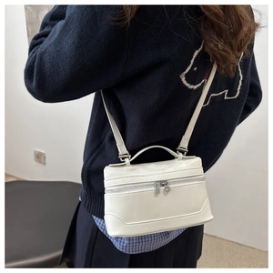 Vue arrière d'un mannequin portant le mini sac boîte blanc brillant à double fermeture