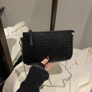 Detailed view of black woven chain bag with silver zipper and rectangular shape