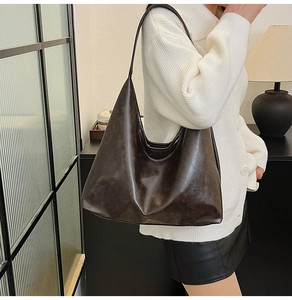 Close-up of a large dark brown hobo shoulder bag with a vintage oil wax leather texture