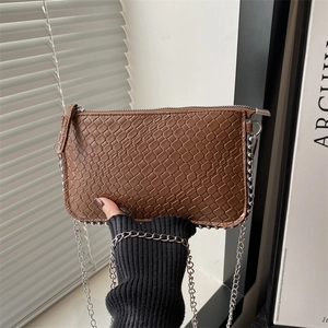 Detail shot of brown embossed faux leather bag with silver chain strap and beaded trim