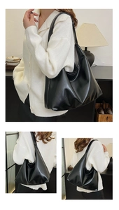 Detailed view of large black leather hobo bag showing soft texture and drape on shoulder