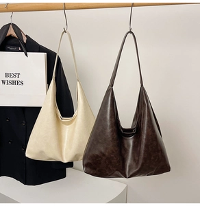 Detail view of large minimalist hobo bags in beige and dark brown soft faux leather