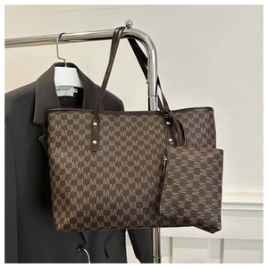 Detail of stylish brown tote bag set with monogram print and small zipper pouch