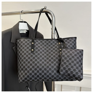 Detail of grey monogram tote bag set including matching small zippered pouch and metal hardware