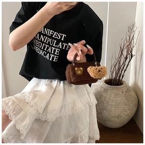 Detail der braunen Plüschtasche mit Teddybär-Stickerei und passendem Anhänger