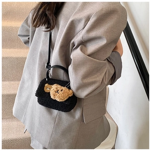 Detail der schwarzen Teddy-Tasche mit süßen Bären-Anhängern und Leder-Handgriff