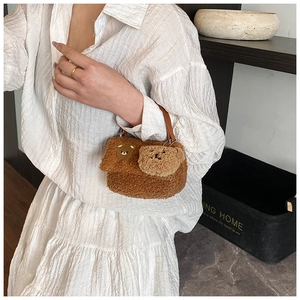 Detail der braunen Teddy-Plüschtasche mit Bärenstickerei und passendem 3D-Bärenanhänger