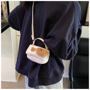 Detail einer Plüschtasche in Weiß mit zwei niedlichen Bären-Stickereien zum Umhängen