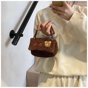 Nahaufnahme der braunen Plüschhandtasche mit Teddybär-Stickerei und Ledergriff
