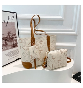 Ensemble de trois sacs fourre-tout vintage avec imprimé monogramme et poignées en cuir brun