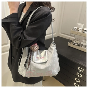 Silberne Samt-Schultertasche mit rosa Stickerei und süßem Teddybär-Anhänger als Detail