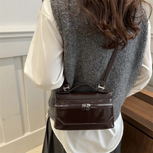 Fashionable dark brown patent leather box bag with silver zippers and crossbody strap