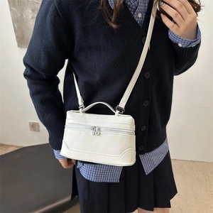 Minimalist white rectangular box bag with silver zippers and adjustable shoulder strap