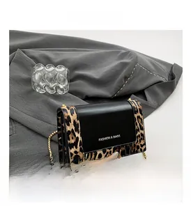 Detail view of leopard print square bag with gold chain and Fashion & Bags lettering