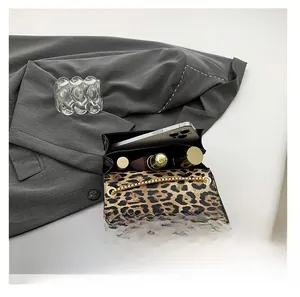 Detail showing inner capacity of leopard print chain bag with phone and lipstick