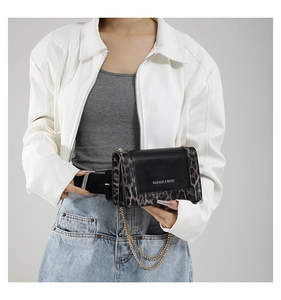 Detail of leopard print chain bag showing versatile belt and shoulder strap styling