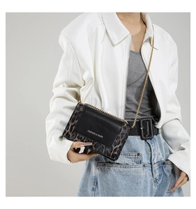 Close-up of leopard print patchwork crossbody bag with gold chain and FASHION & BAGS logo