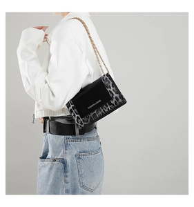 Detail shot of leopard print chain bag with gold strap and Fashion text on model