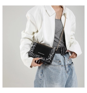 Detail of leopard print crossbody bag with gold chain strap and fashion lettering