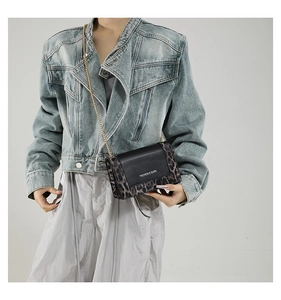 Close-up of leopard print patchwork chain bag worn with a casual denim jacket outfit