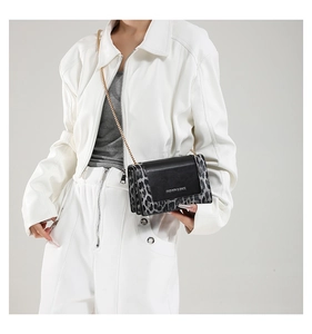 Detail showing leopard print texture and golden chain strap on this stylish crossbody bag
