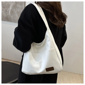 Détail d'un sac cabas blanc minimaliste montrant sa texture souple et sa grande capacité