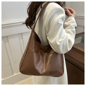 Vue détaillée du grand sac cabas en cuir marron foncé avec étiquette de mode gaufrée