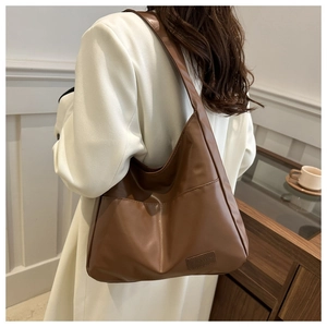 Détail du sac cabas en similicuir marron avec texture souple et écusson logo