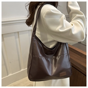 Détail du sac hobo marron café en cuir PU avec poche frontale et écusson tendance