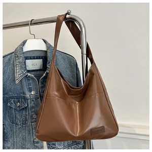 Détail de sac cabas en cuir PU marron avec étiquette embossée et texture de qualité