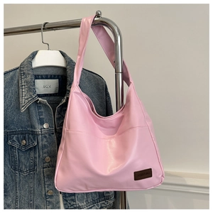 Vue détaillée du sac cabas rose brillant en PU avec un petit écusson en cuir marron