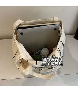 Interno spazioso di una borsa in tela color crema con laptop, ombrello e vari libri