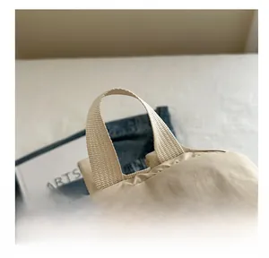 Detail showing the sturdy woven handle and fine stitching of the khaki nylon backpack