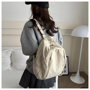 Minimalist beige lightweight nylon backpack for students shown in a lifestyle home setting