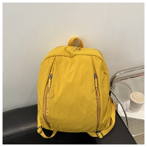 Detailed view of the bright yellow water-resistant nylon backpack on a modern chair