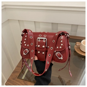 Detail view of red punk baguette bag with silver studs and metal grommet strap buckle