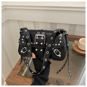 Close-up of punk style rivet bag with silver metal eyelets and wide strap buckle