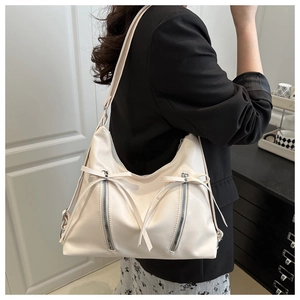 Detail der cremeweißen PU-Shopper-Tasche mit Schleifendekor und Reißverschluss-Design