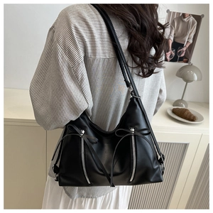 Detailed back view of a black PU tote bag featuring chic bow ribbons and silver zippers
