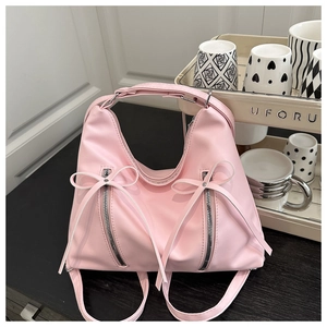 Detail of pink hobo bag featuring silver zippers and sweet bow ribbon decorations