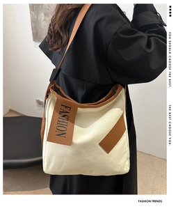 Close-up of stylish canvas tote bag with brown fashion tag and adjustable strap details